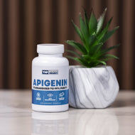 Supplement bottle labeled 'Apigenin' on a surface with a plant in the background