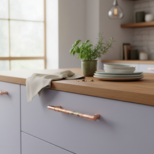Load image into Gallery viewer, Copper cabinet handles with a rainbow effect bar section on light grey cabinets