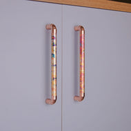Antique copper pull handles with rainbow effect on grey cabinet doors